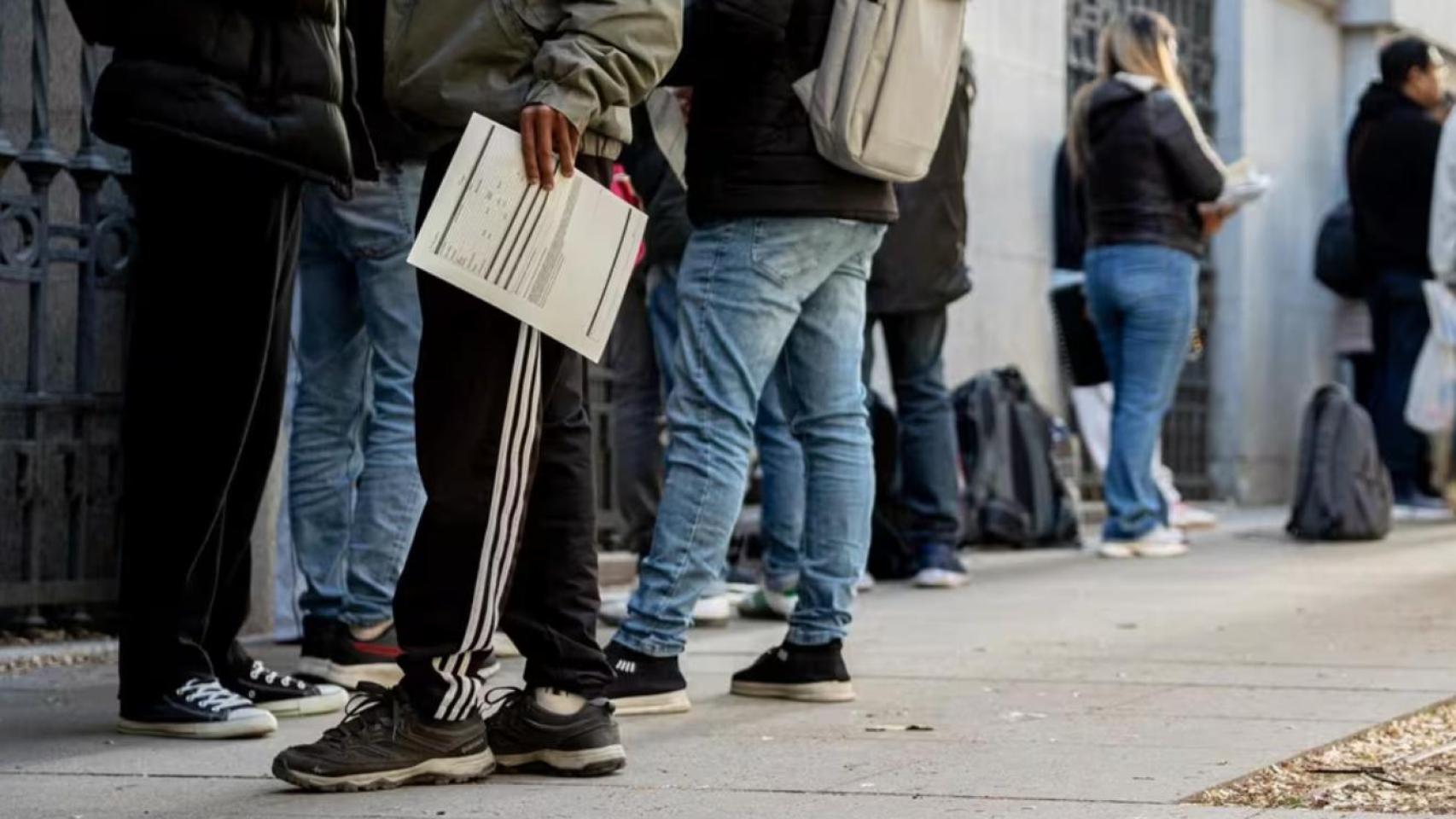 Archivo - Varias personas hacen cola para conseguir documentación de la regularización en una Oficina de Asistencia en Materia de Registro-EP