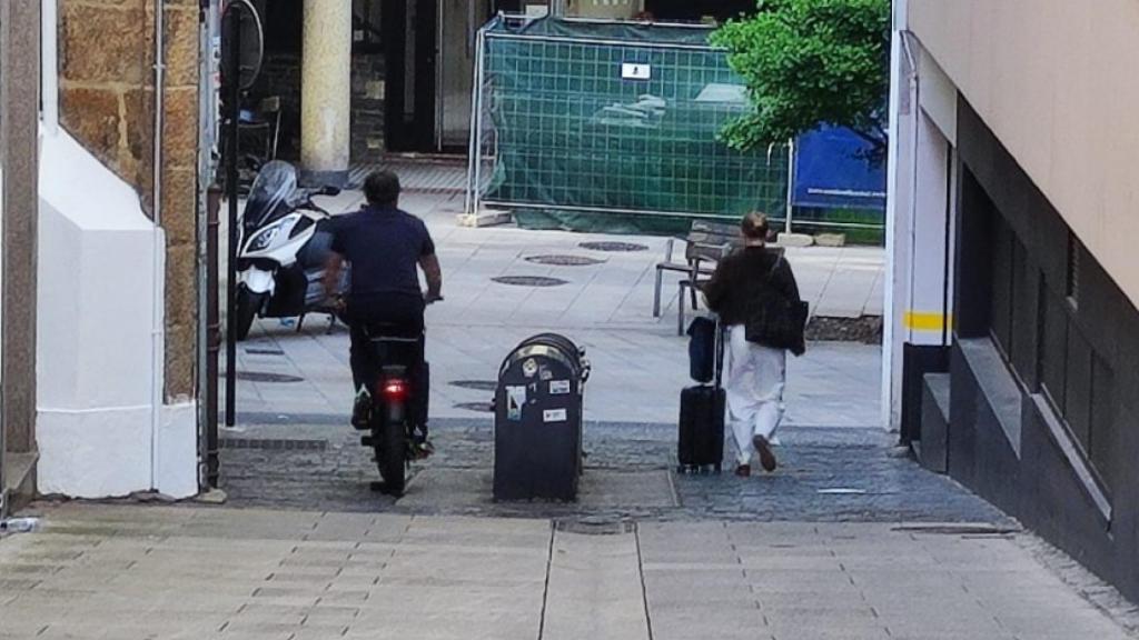 Una mujer, a la derecha, con su equipaje tras salir de una VUT del centro de A Coruña.