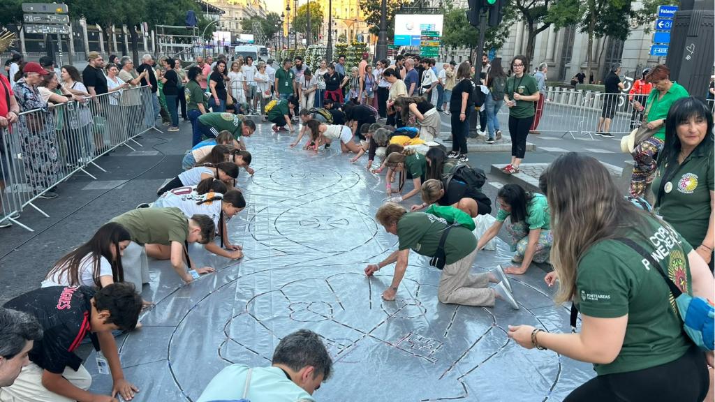 Voluntarios de Puenteareas realizando las alfombras en la calle de Alcalá para la misa del Corpus Christi.