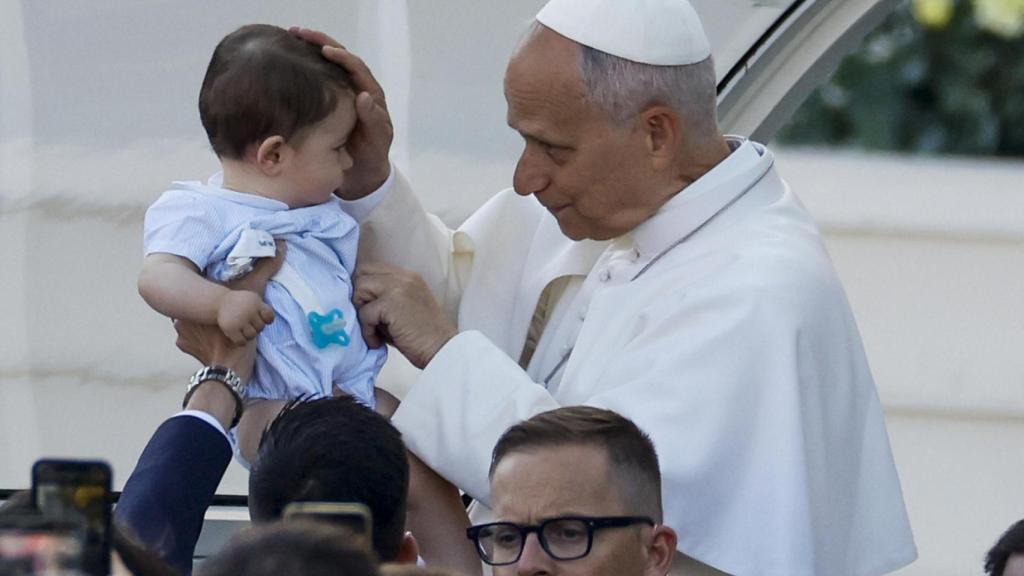 El papa León XIV bendice a un niño durante la procesión del Corpus Christi tras la misa oficiada este domingo en la Plaza de Cibeles de Madrid