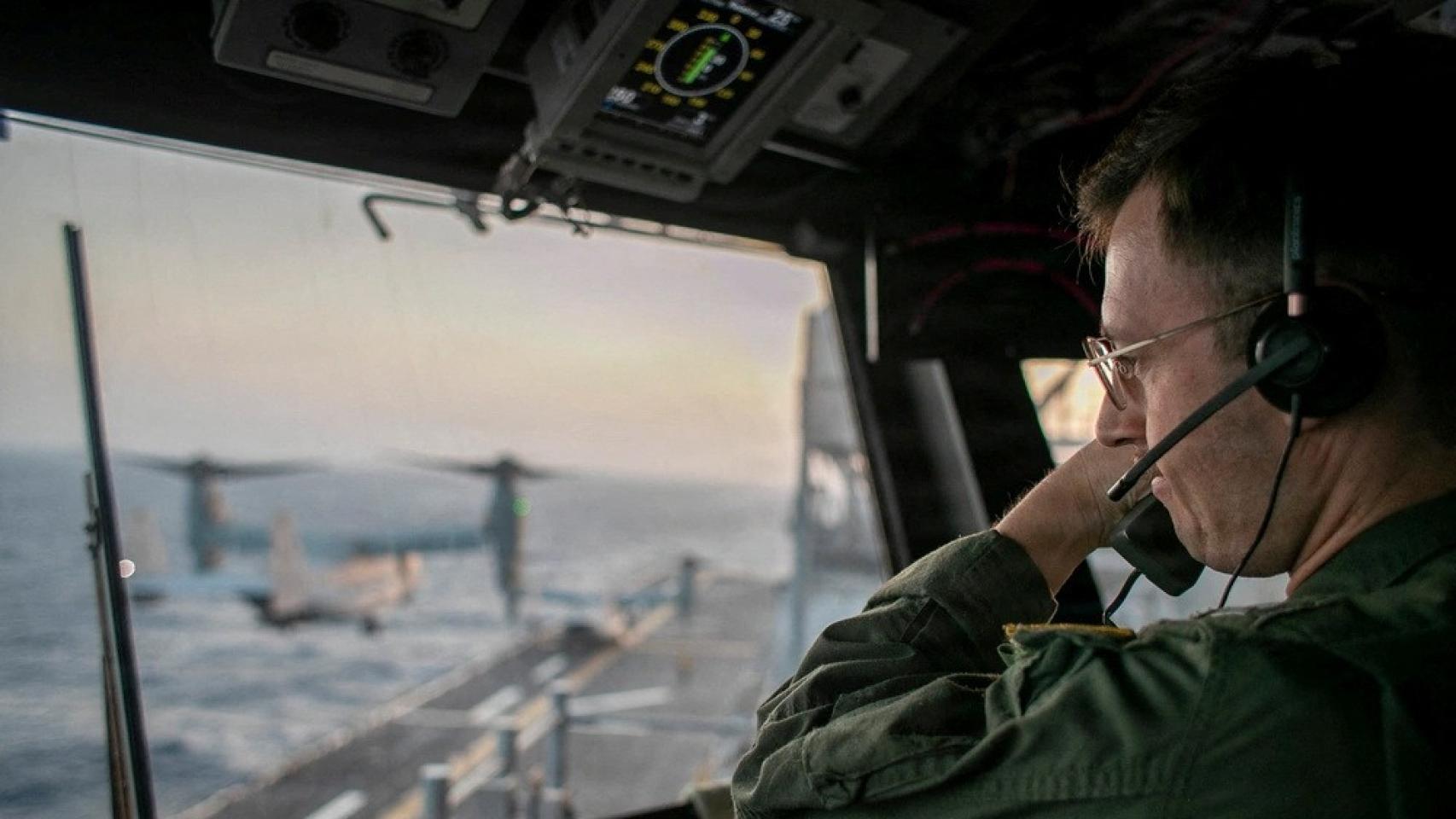 Un oficial naval a bordo del USS Tripoli (LHA 7) supervisa las operaciones de vuelo desde la torre de control mientras el buque de asalto anfibio navega en el mar Arábigo. 