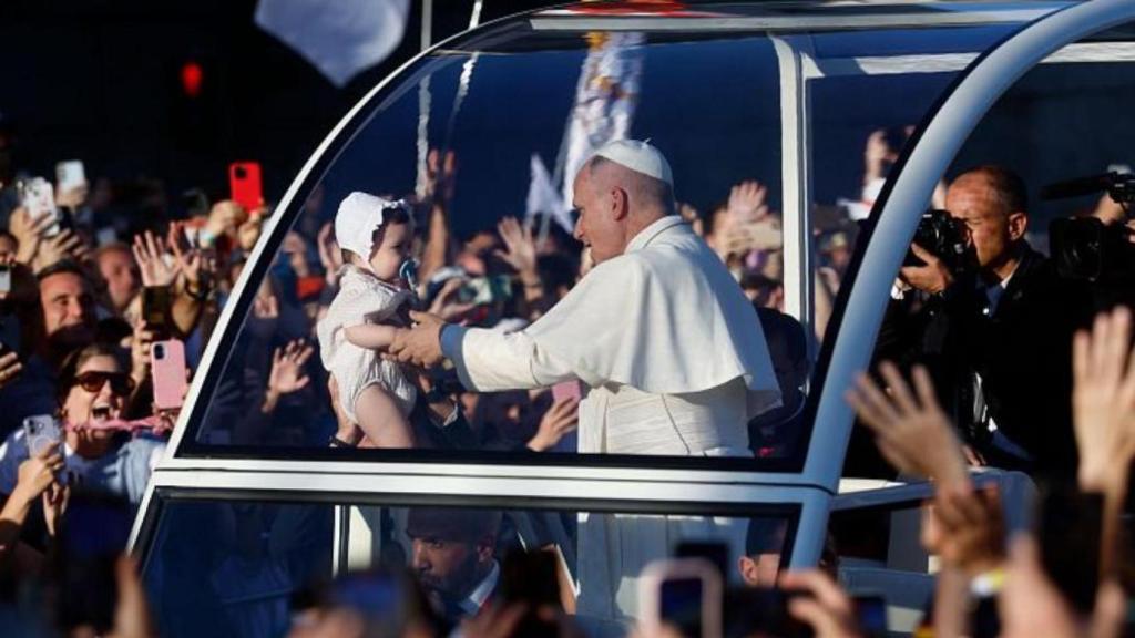 El Papa abraza a un niño durante su llegada a la Vigilia. 