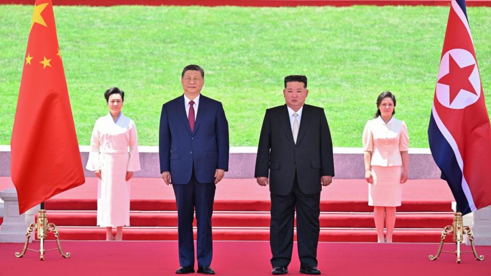 El presidente chino Xi Jinping y su esposa Peng Liyuan, recibidos en Piongyang por el líder sumpremo de Corea del Norte, Kim Jong-un y su esposa Ri Sol-ju.