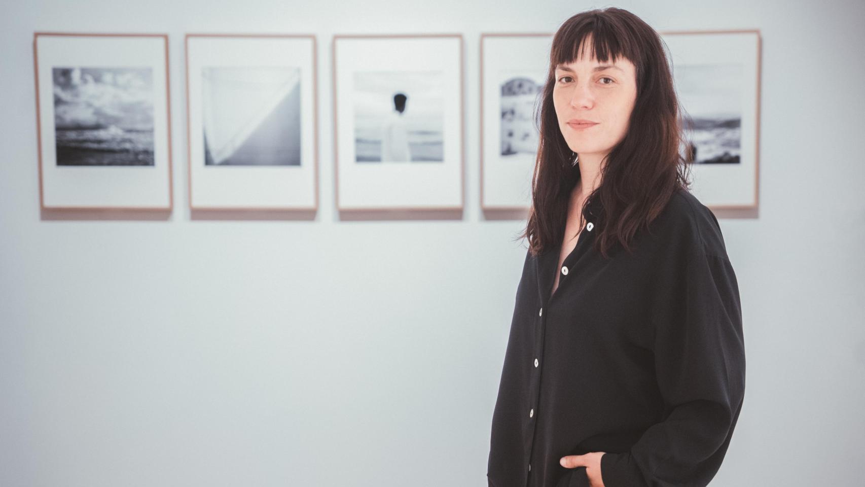 Irene Zottola posa junto a sus obras en la exposición 'En su piel. Miradas por la integración'.
