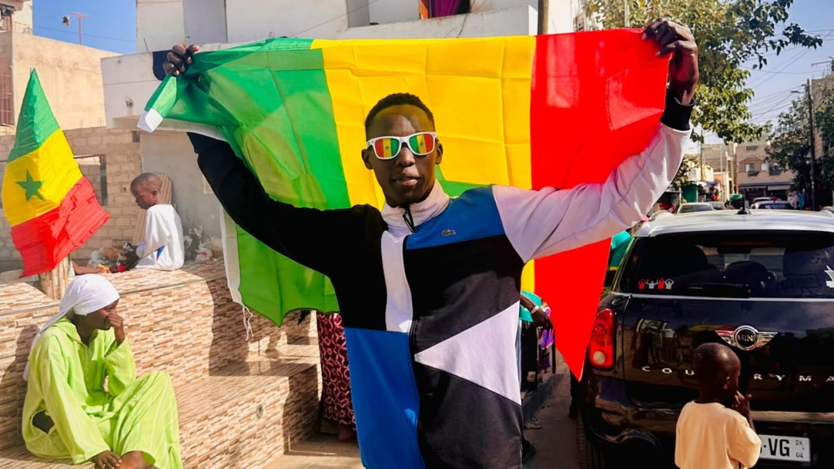Elass con una bandera de Senegal en su país.