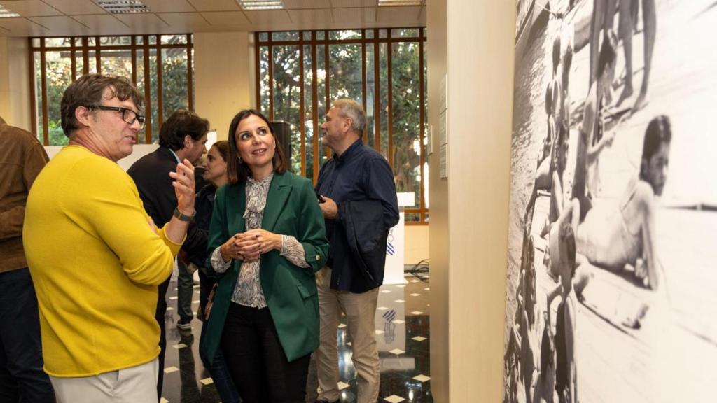El fotógrafo Rafa Arjones enseña a la directora general de Comunicación, Belén Ríos, las fotografías de su padre, Perfecto.