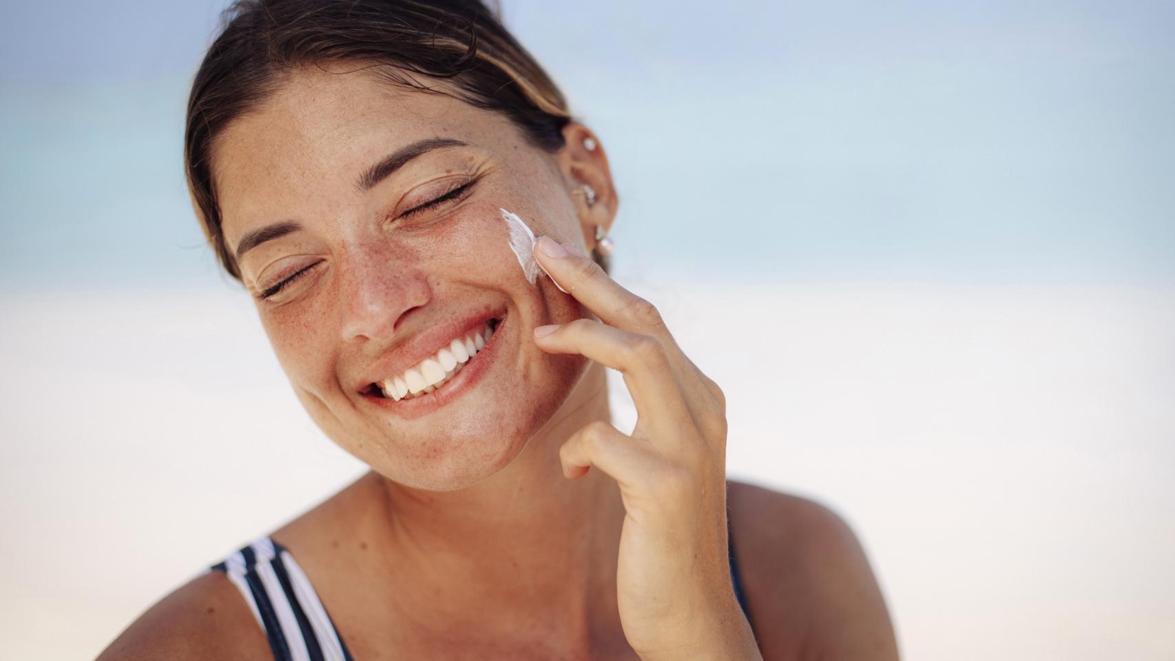Imagen de una mujer echándose crema. 