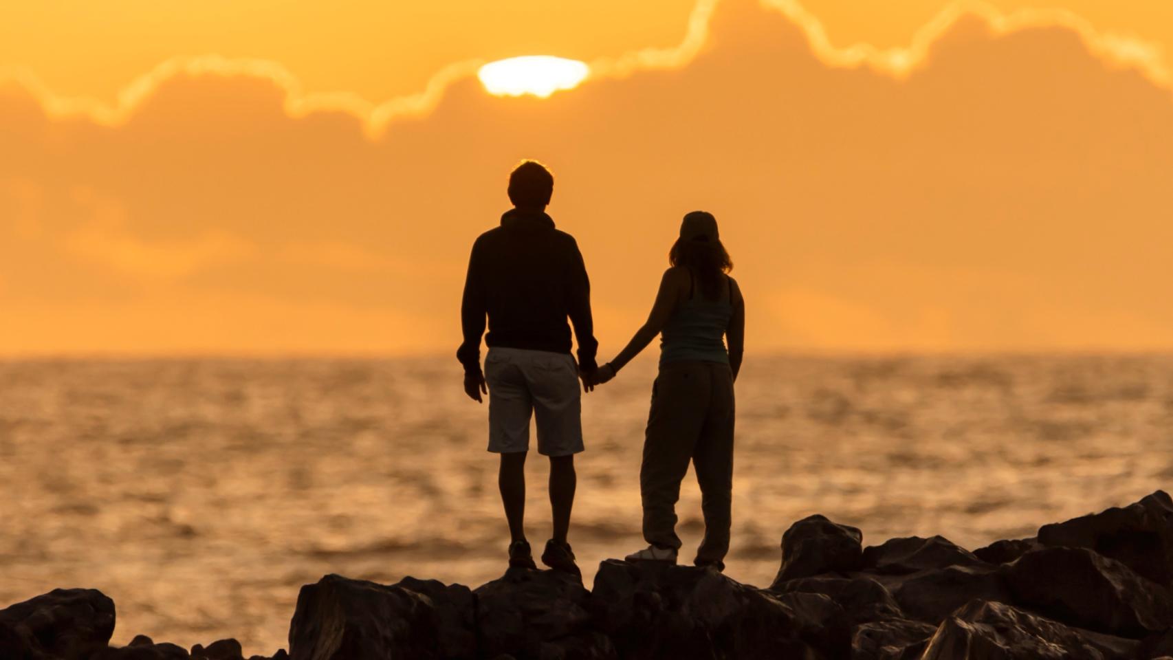 Silueta de una pareja observando la puesta de sol