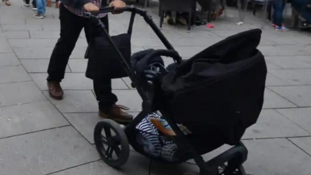 Un hombre pasea con un carrito de bebé