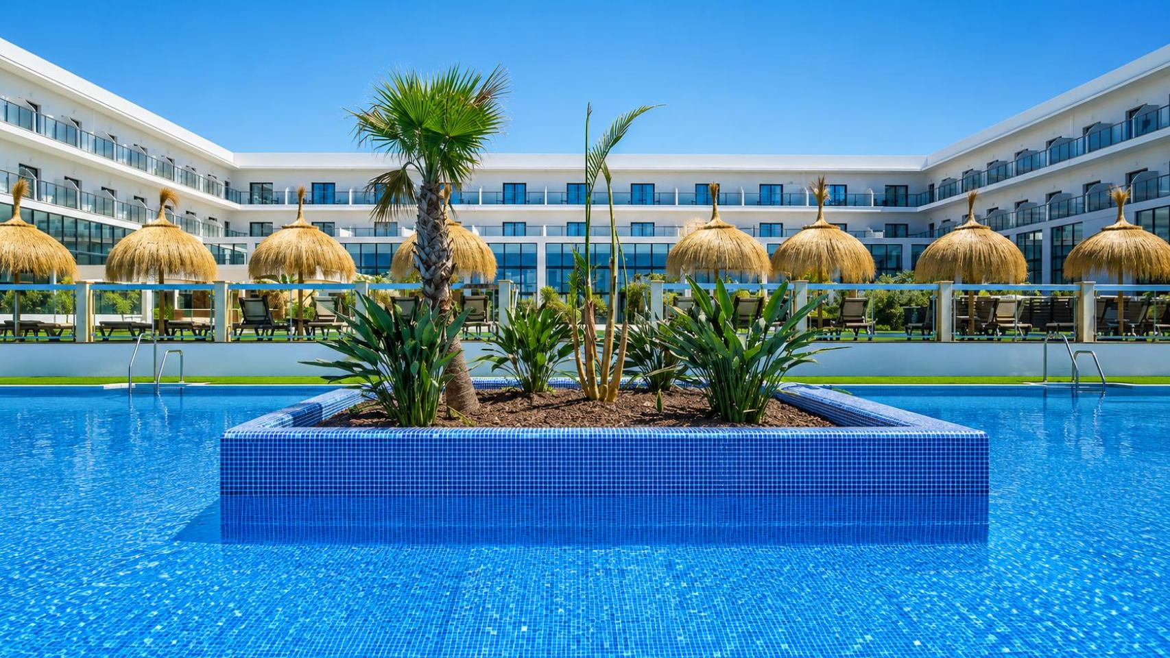 La piscina principal del Cabogata Beach Hotel, con el edificio del complejo al fondo.