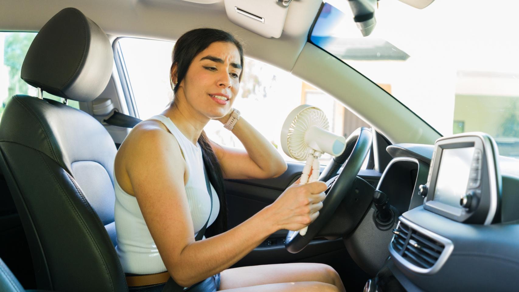 Una conductora con un ventilador portátil