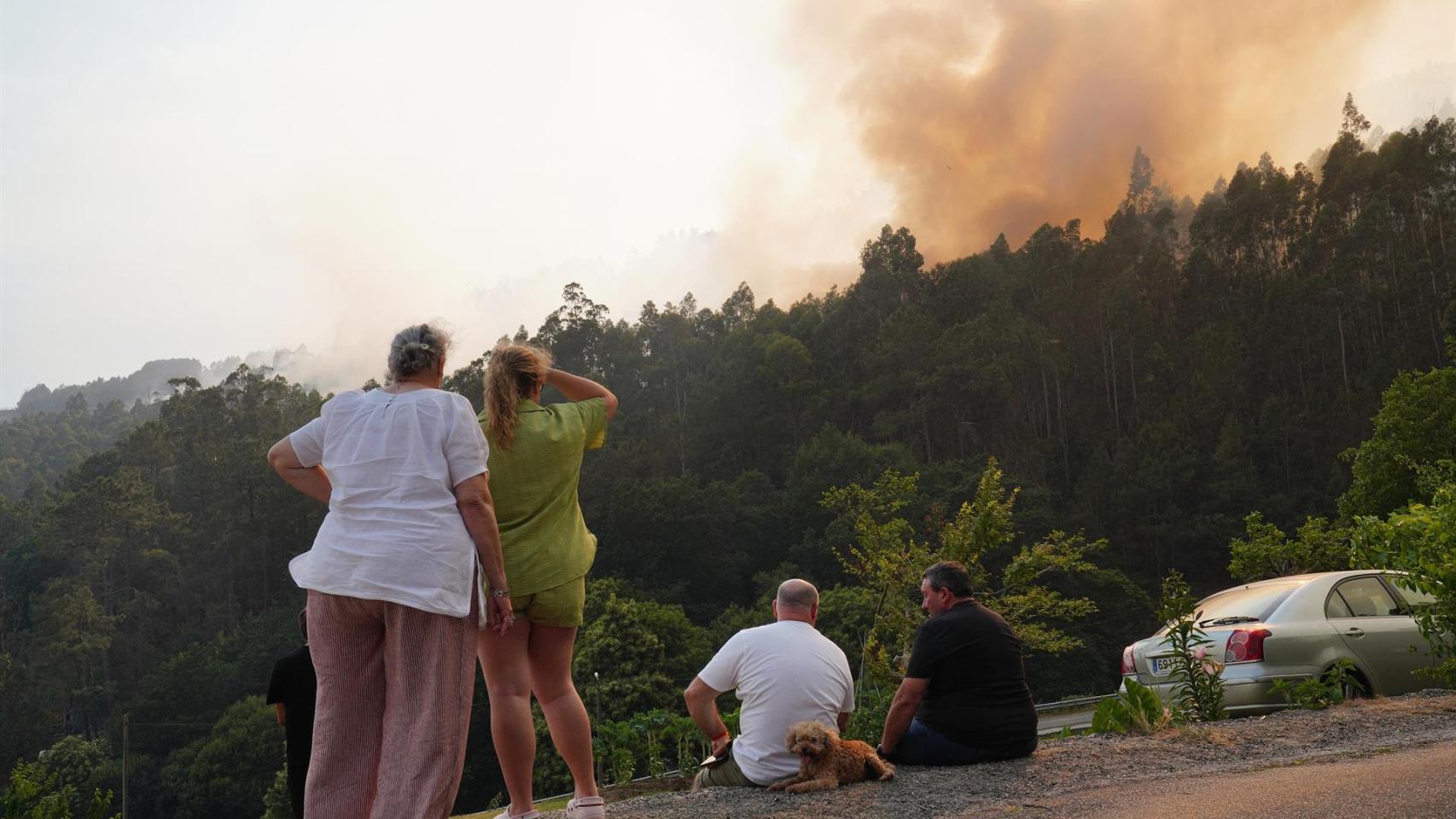 Varias personas observan el incendio en la parroquia de Herbón, en Padrón