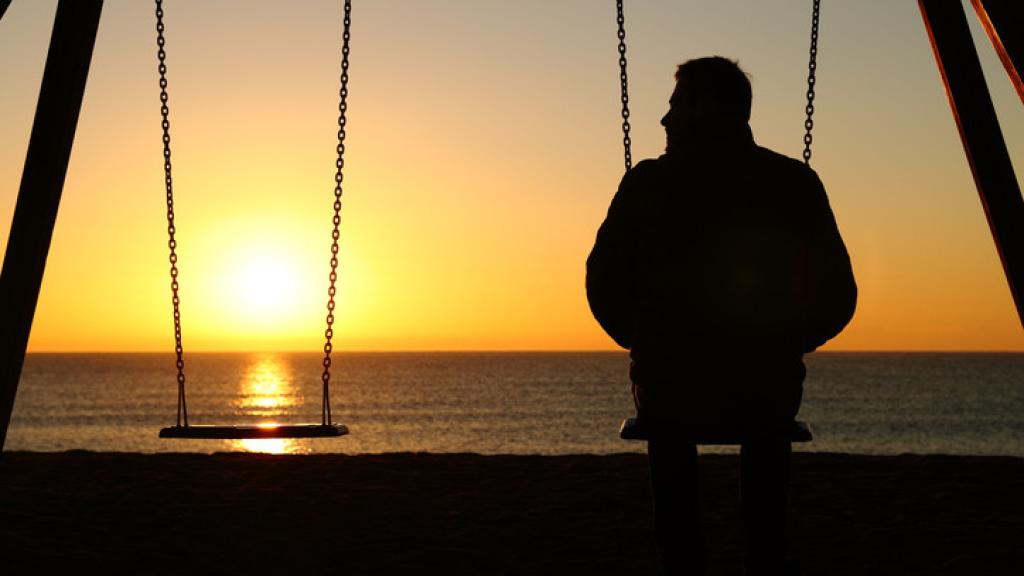 Imagen de archivo de una persona frente a una puesta de sol.