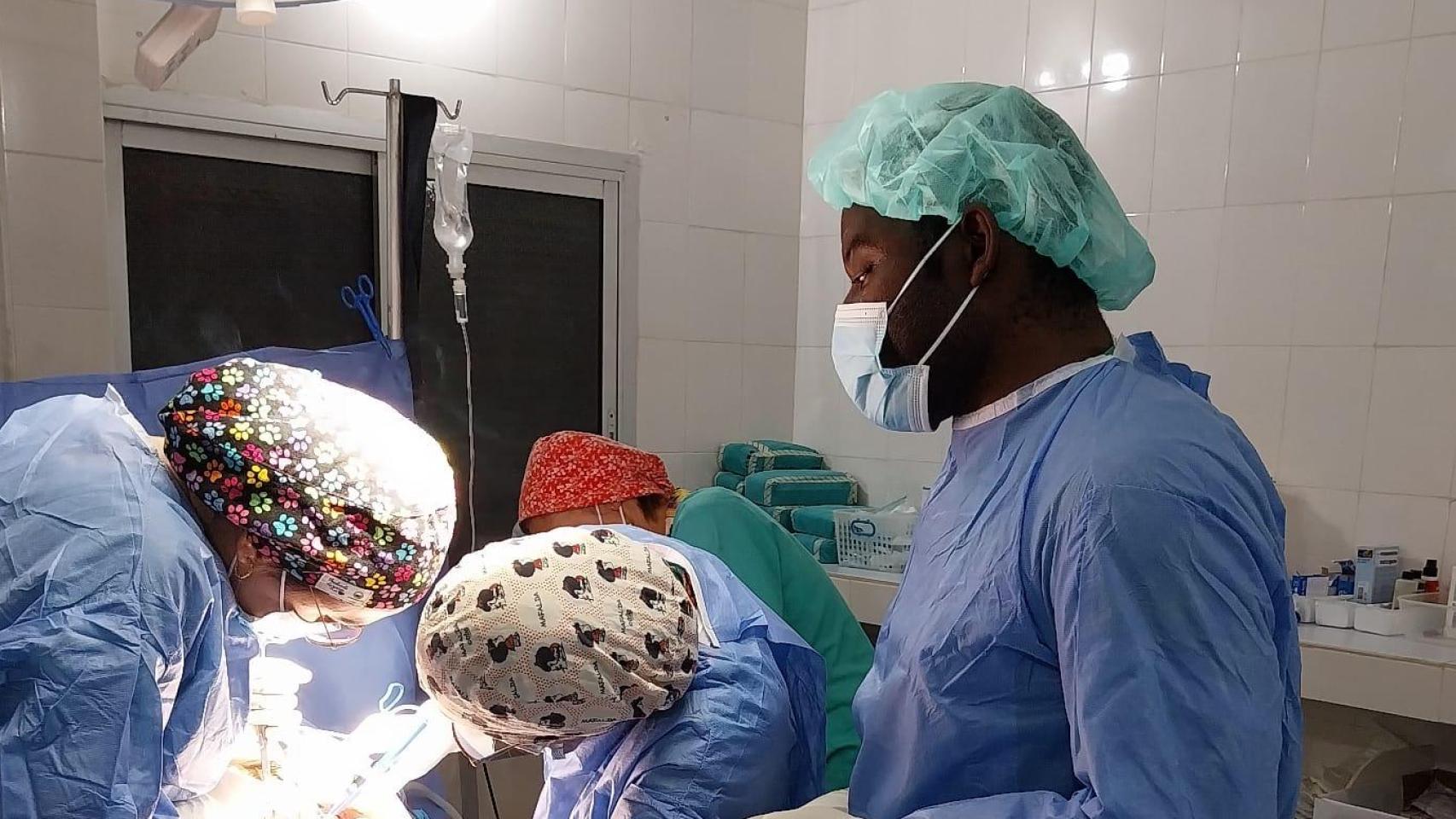 Equipo médico local y de médicas durante una cirugía.