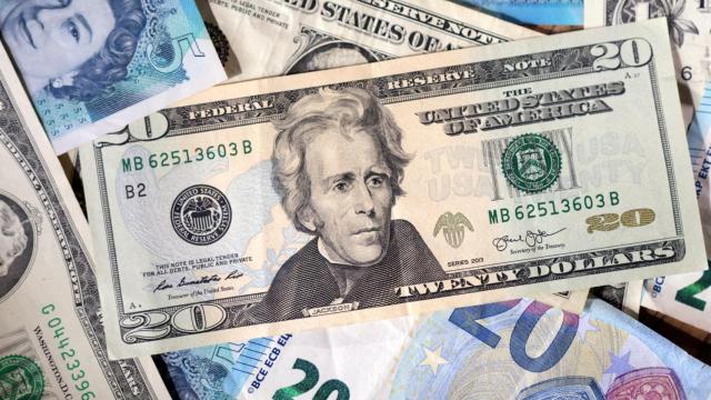 Un billete de 20 dólares sobre varias libras y euros.