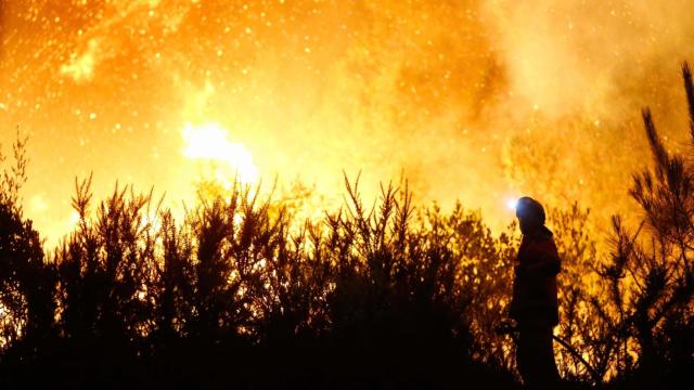 Un vecino ve el avance del fuego, a 25 de agosto de 2025, en A Pobra de Brollón, Lugo, Galicia (España).
