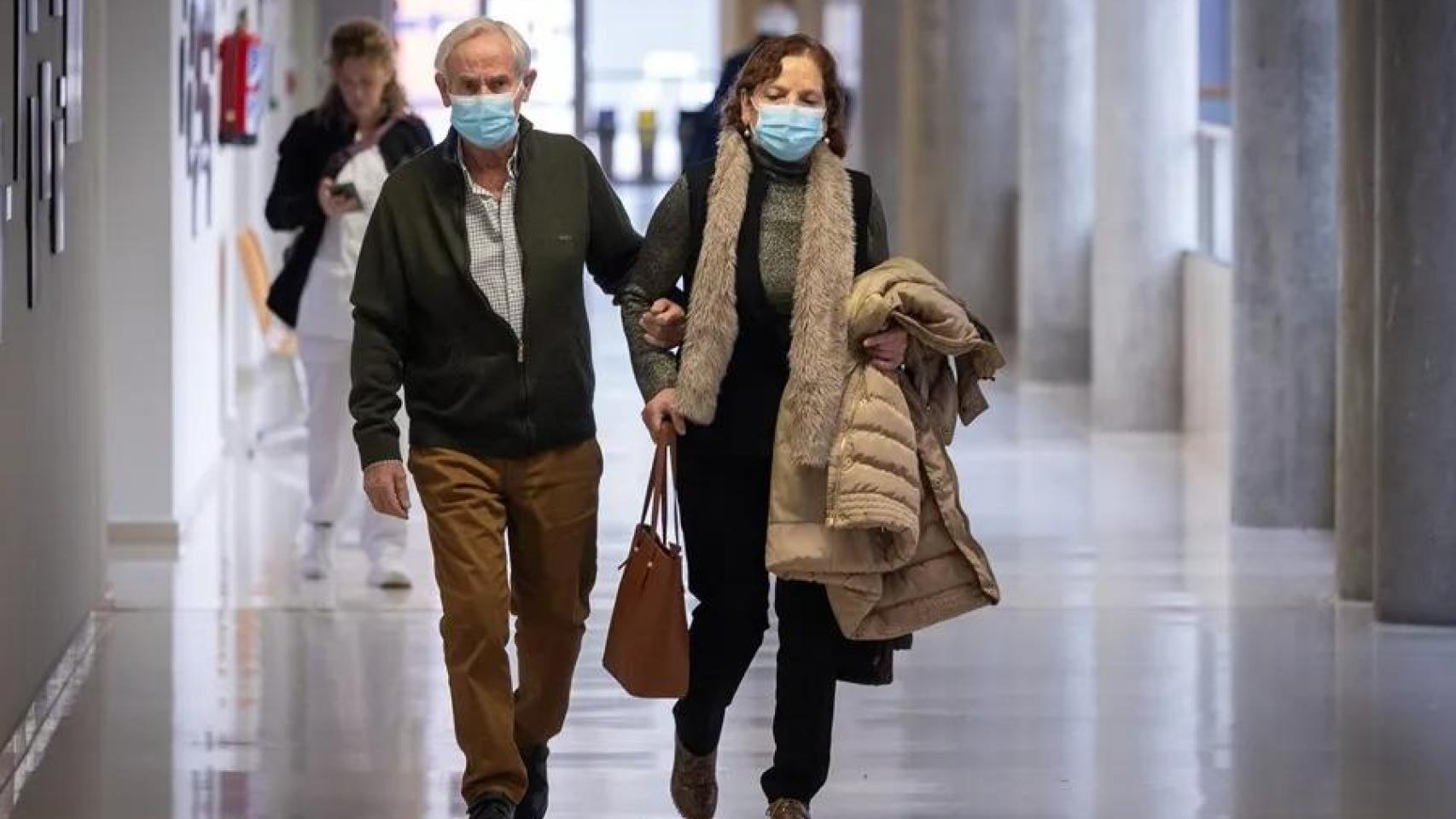 Una pareja con mascarillas en un centro de salud.