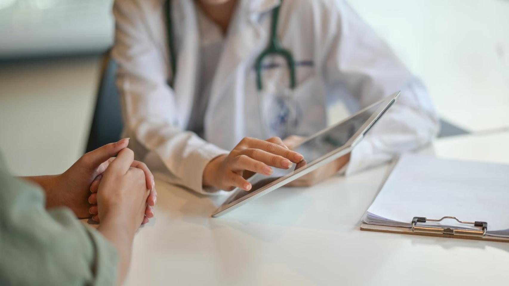 Imagen de archivo de una doctora junto a una paciente en consulta.