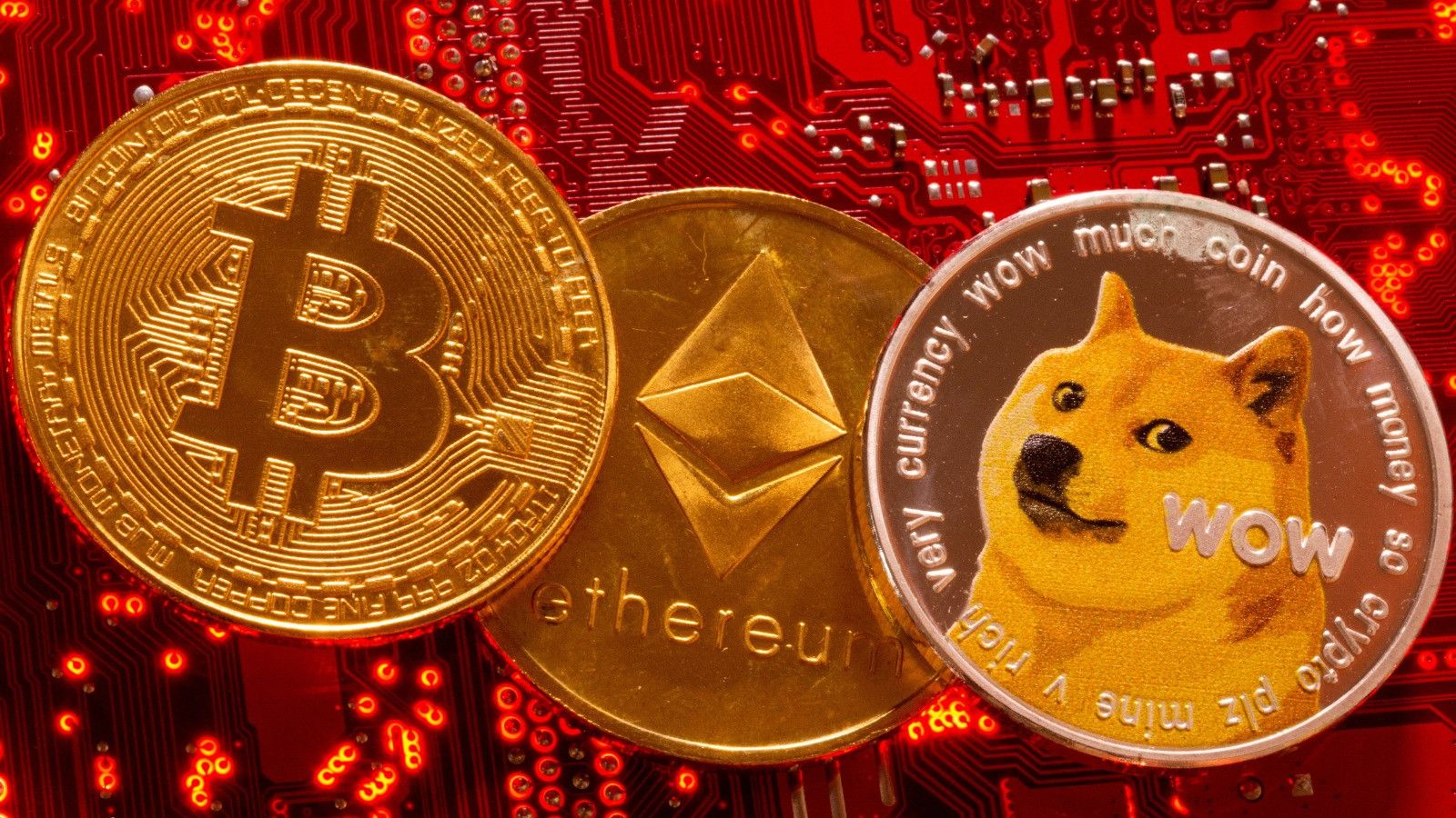 Representación de las criptomonedas Bitcoin, Ethereum y DogeCoin sobra la placa base de un ordenador.