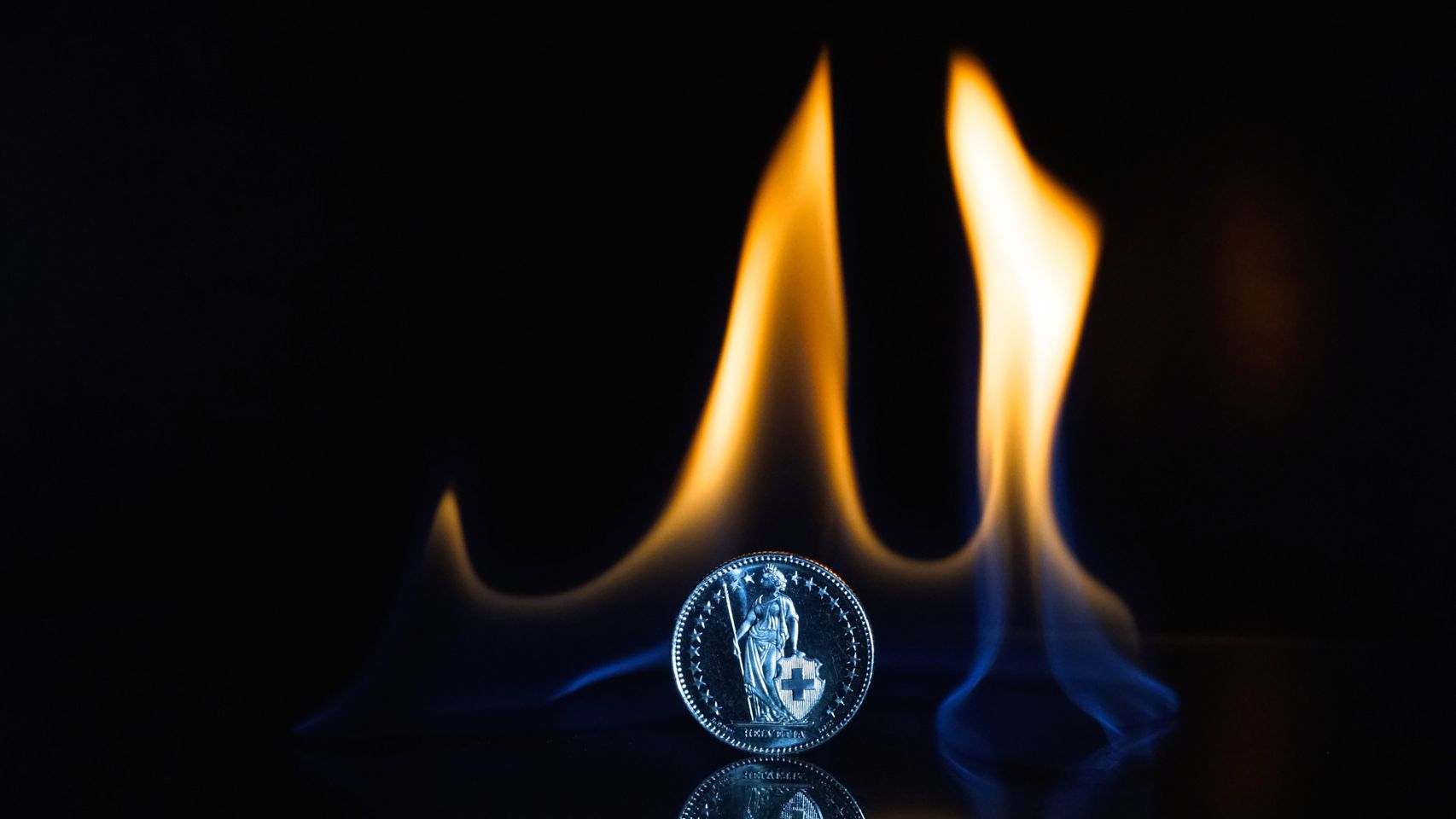 Una moneda de plata en medio de una llama.