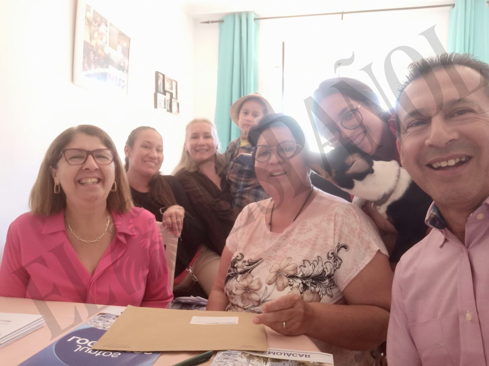 La alcaldesa del PP de Mojácar, Rosa María Cano (1i), junto a la beneficiaria de la cesta de comida de Navidad y los supuestos sobres de voto por correo, en una imagen presuntamente tomada en mayo.