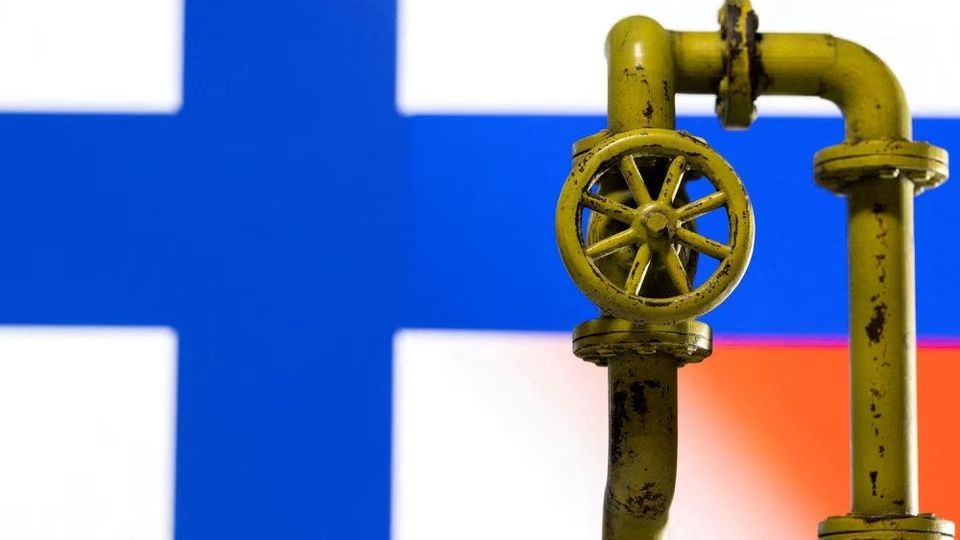 La llave de un gasoducto delante de una bandera de Finlandia.