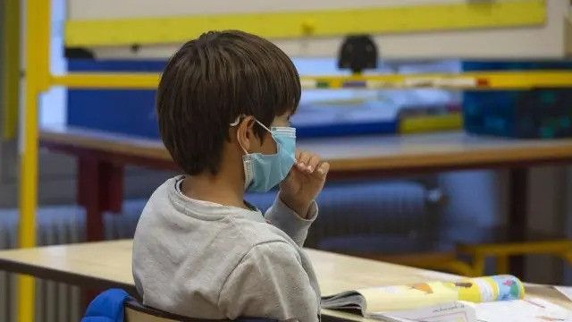 Un niño con mascarilla en el centro escolar