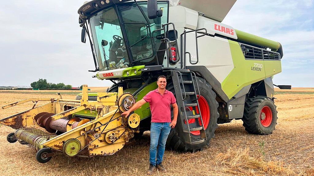 El agricultor Juan José Recio Martín con su cosechadora. 