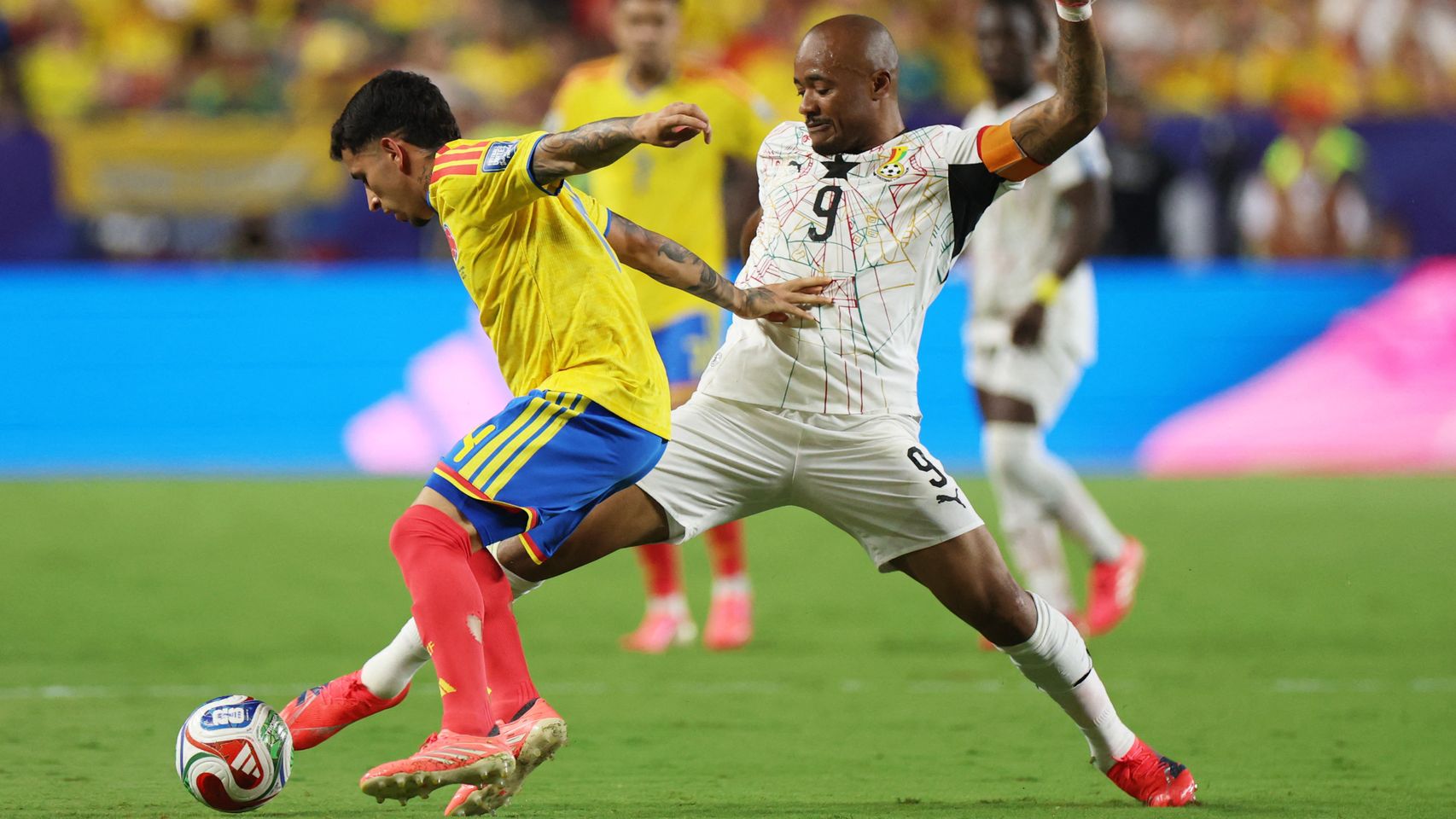 Ayew y Gustavo Puerta pelean por un balón.