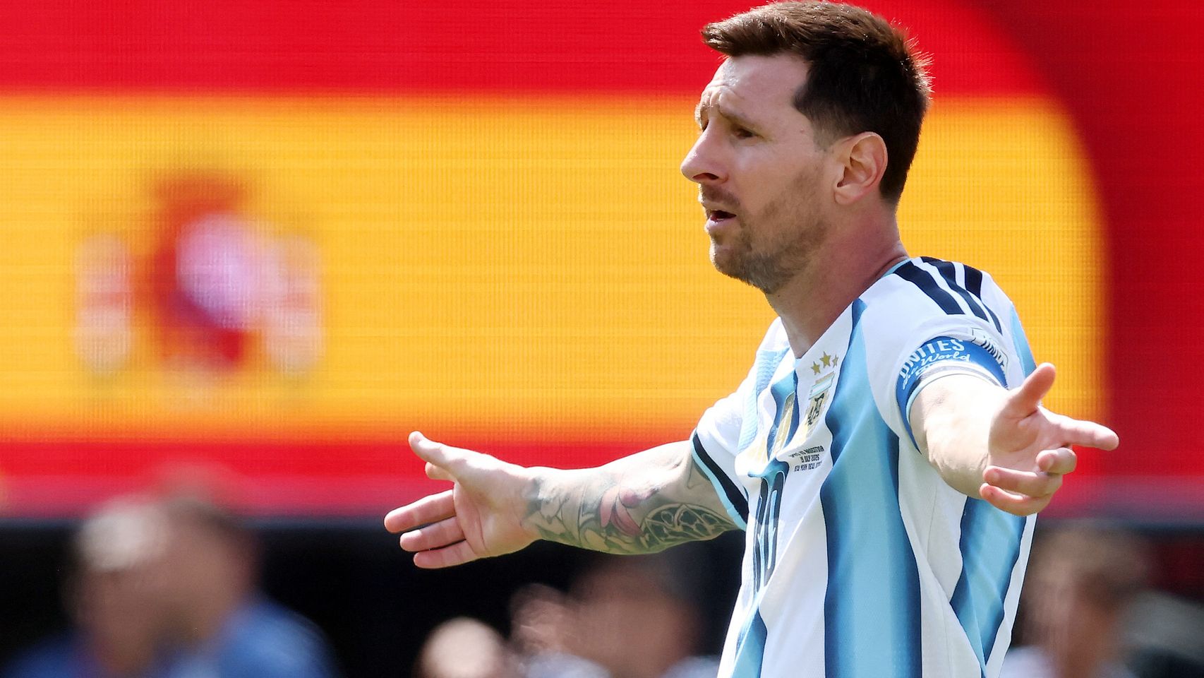 Leo Messi, con una bandera de España al fondo.