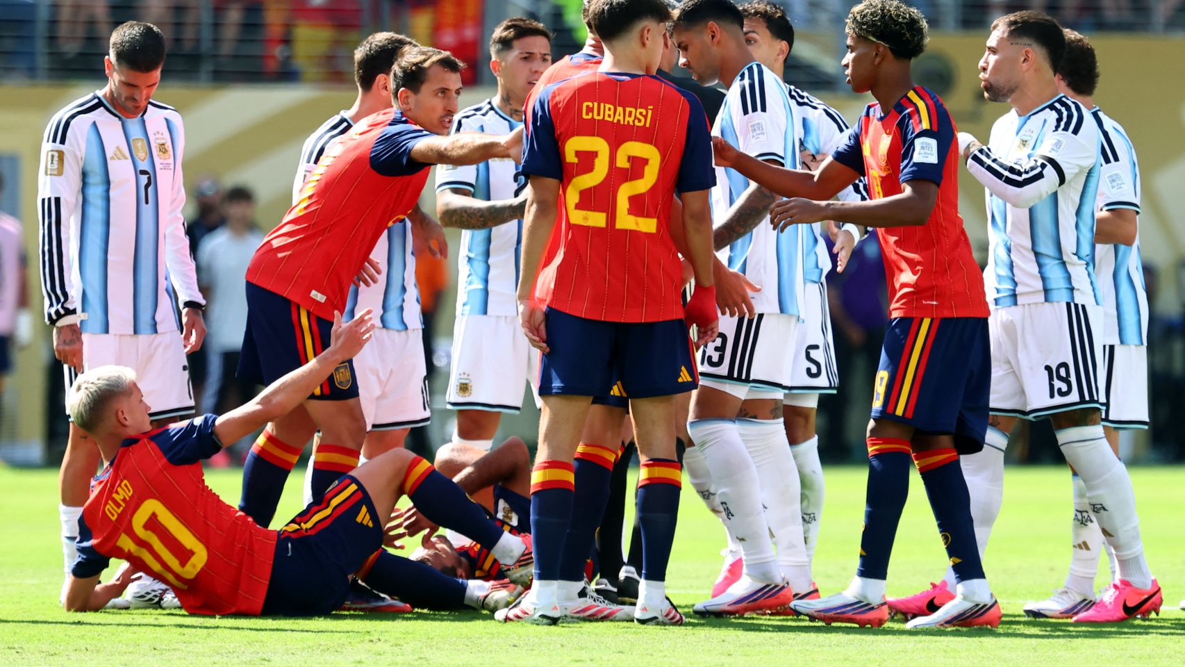 Los jugadores de España y Argentina discuten en el césped.