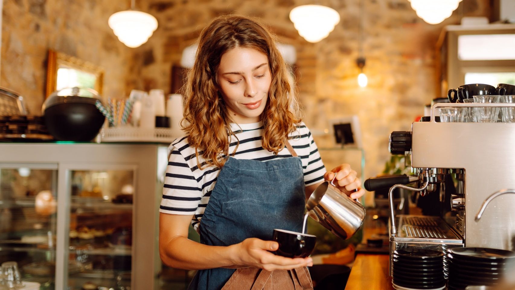 Una camarera preparando un café