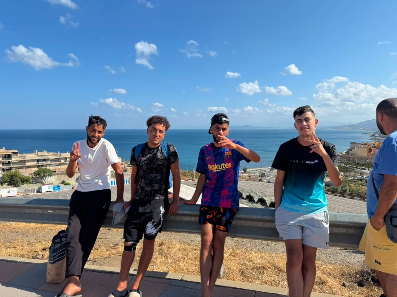 Mohamed, Said, Hassan y Youssef, sentados en una baranda en la Loma Colmenar.