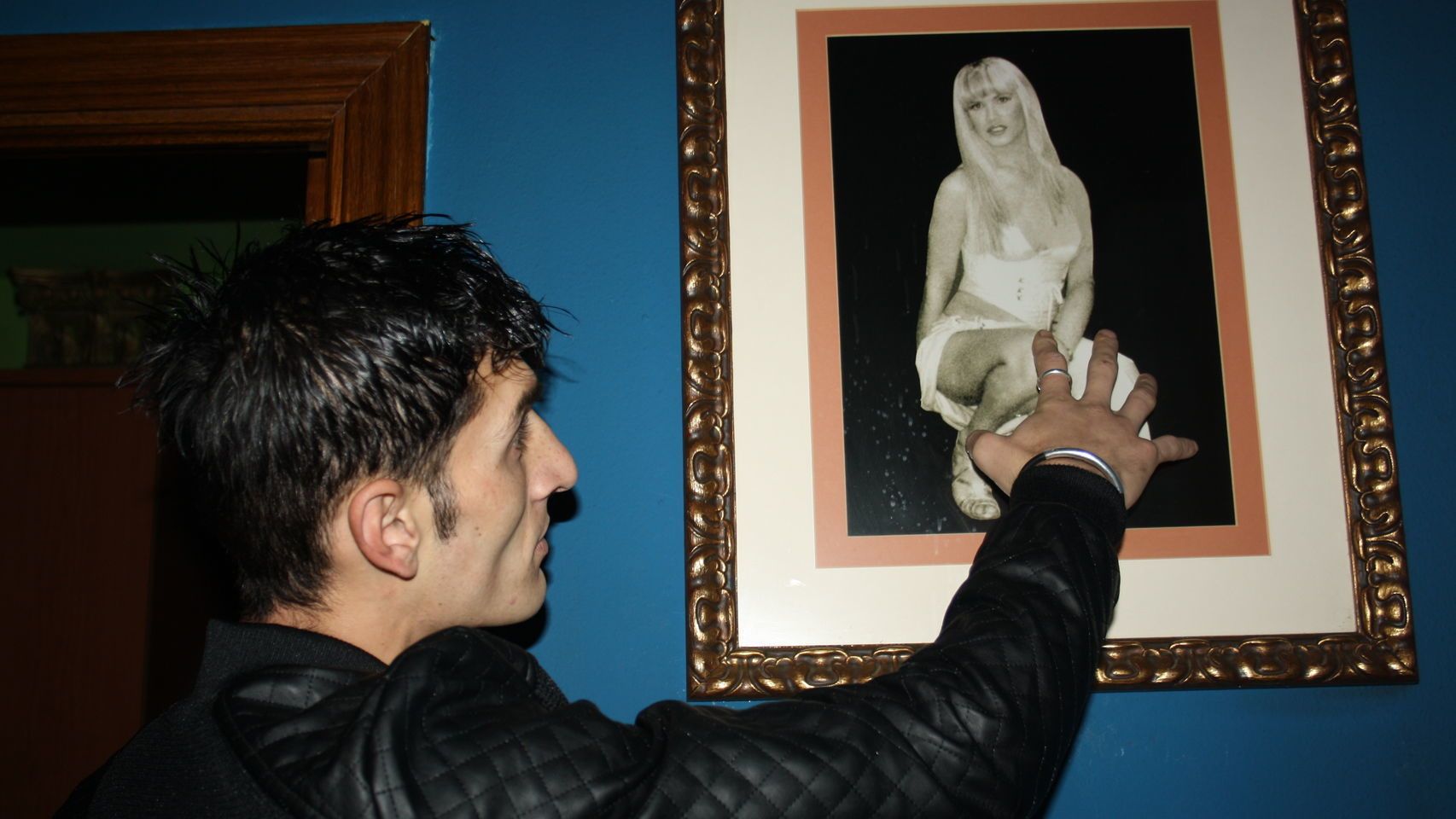 Alin, el novio de La Veneno, frente una fotografía de la artista fallecida.