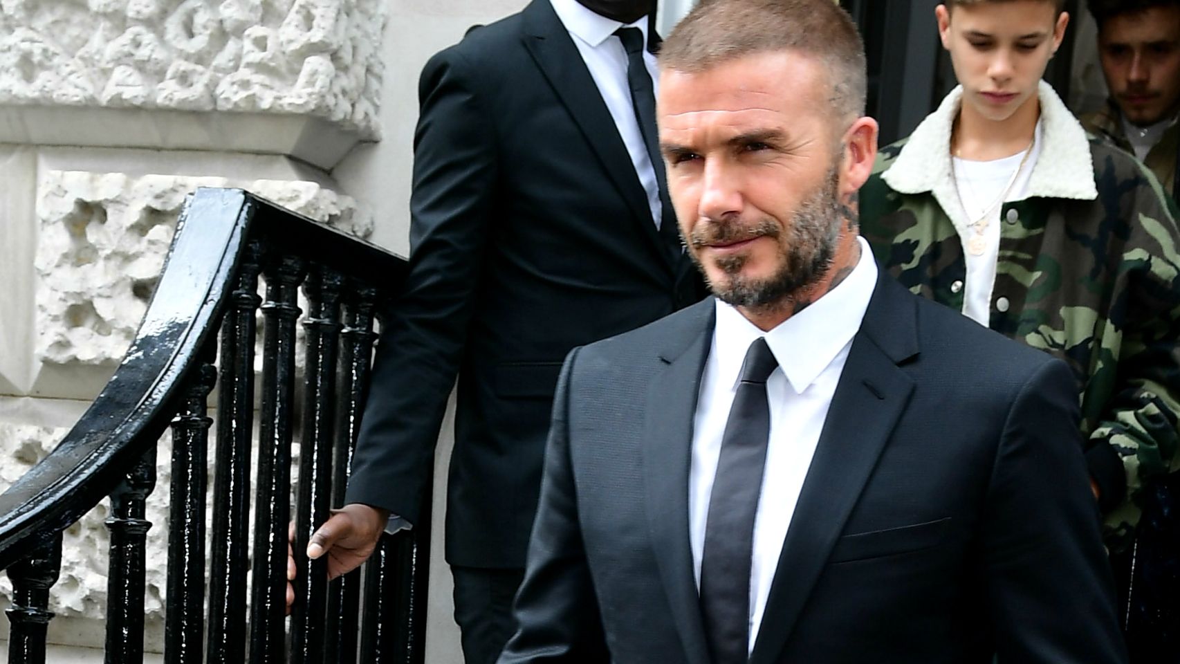 David Beckham vestido de traje para el desfile de su mujer.