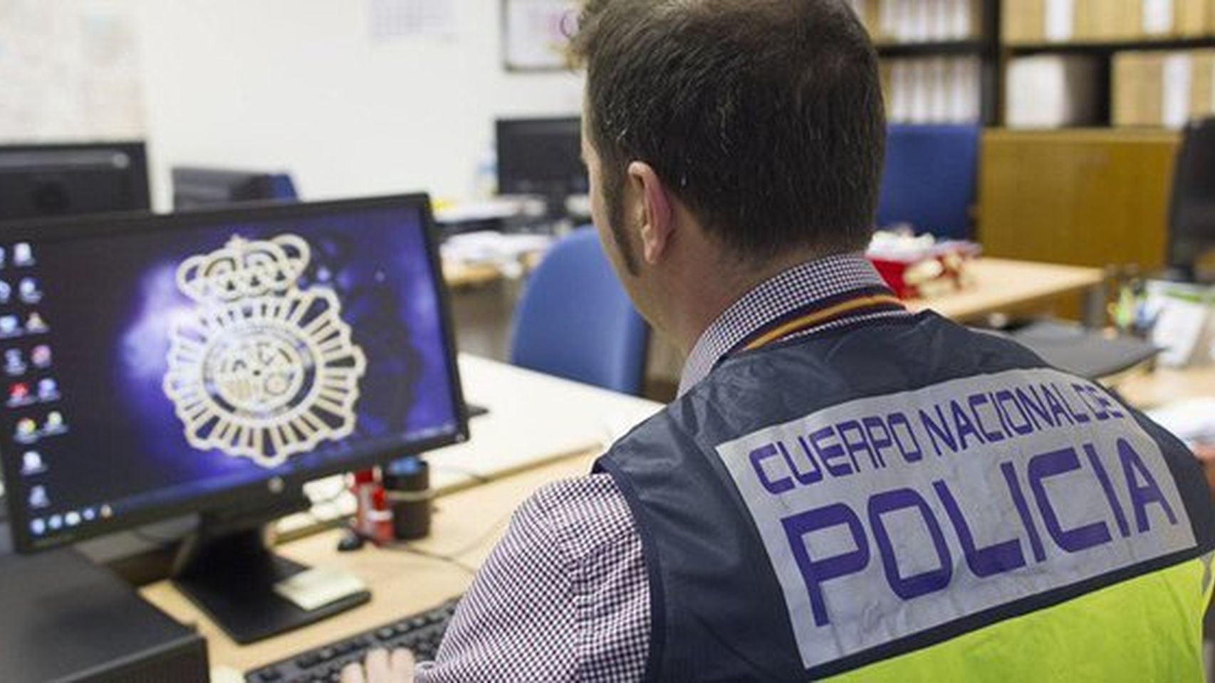 Un agente de Policía Nacional trabajando ante un ordenador.