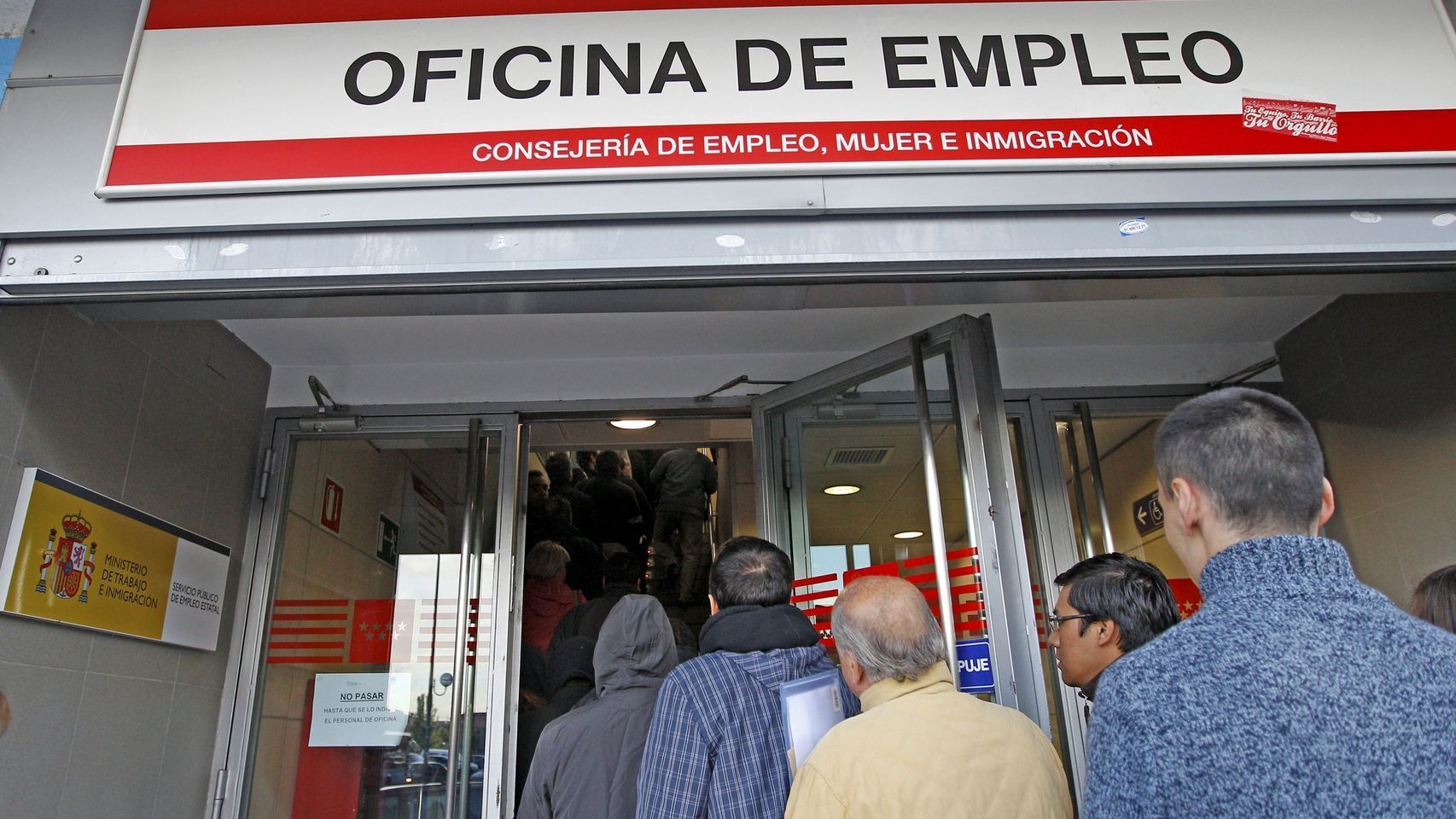 Varios demandantes ante las puertas de una oficina de empleo.
