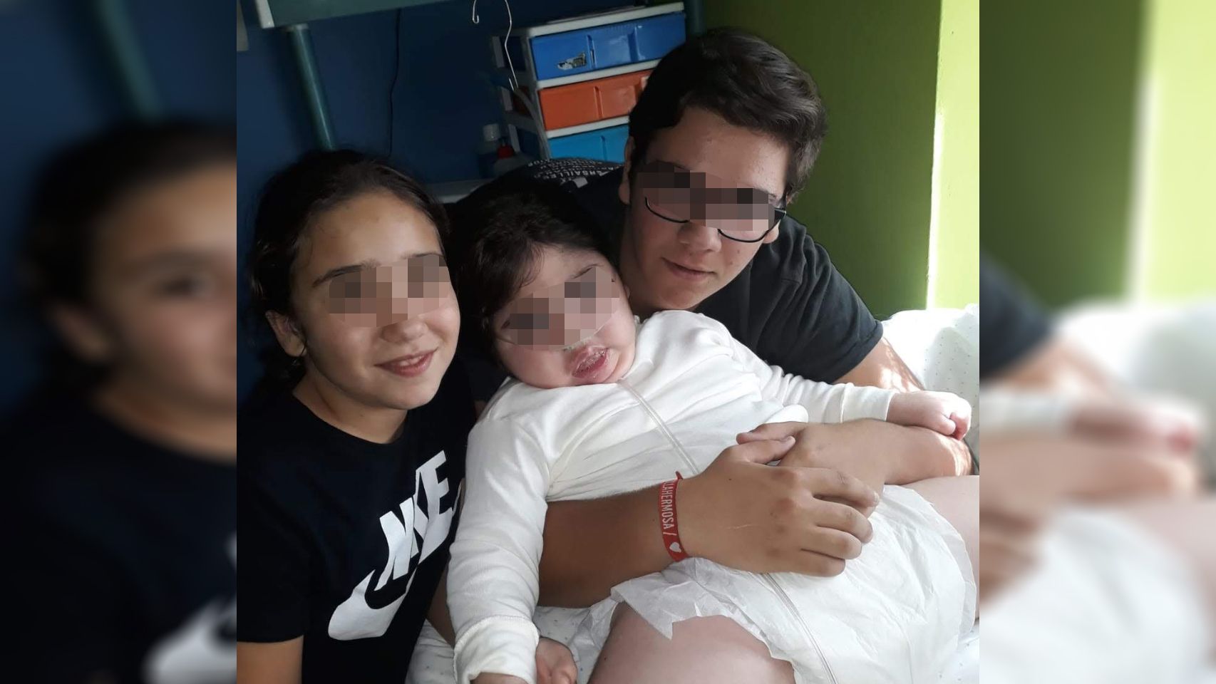 Paula, la menor afectada, en compañía de sus hermanos mayores.