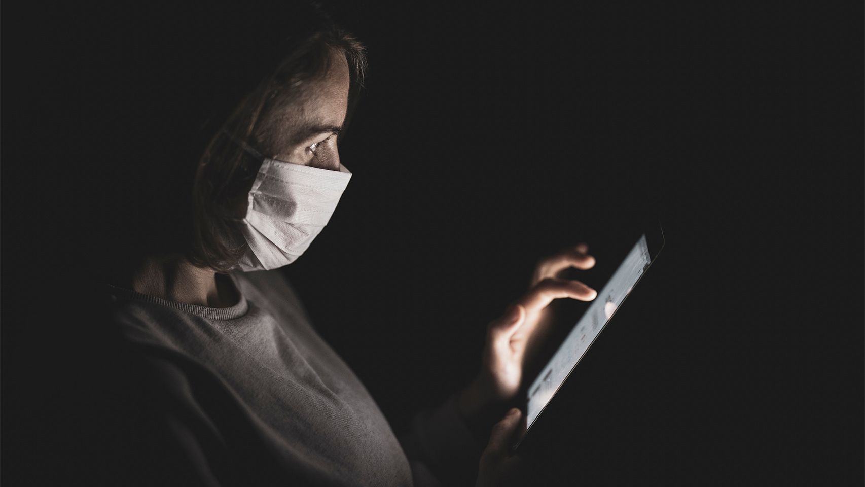 Persona usando un smartphone con mascarilla.
