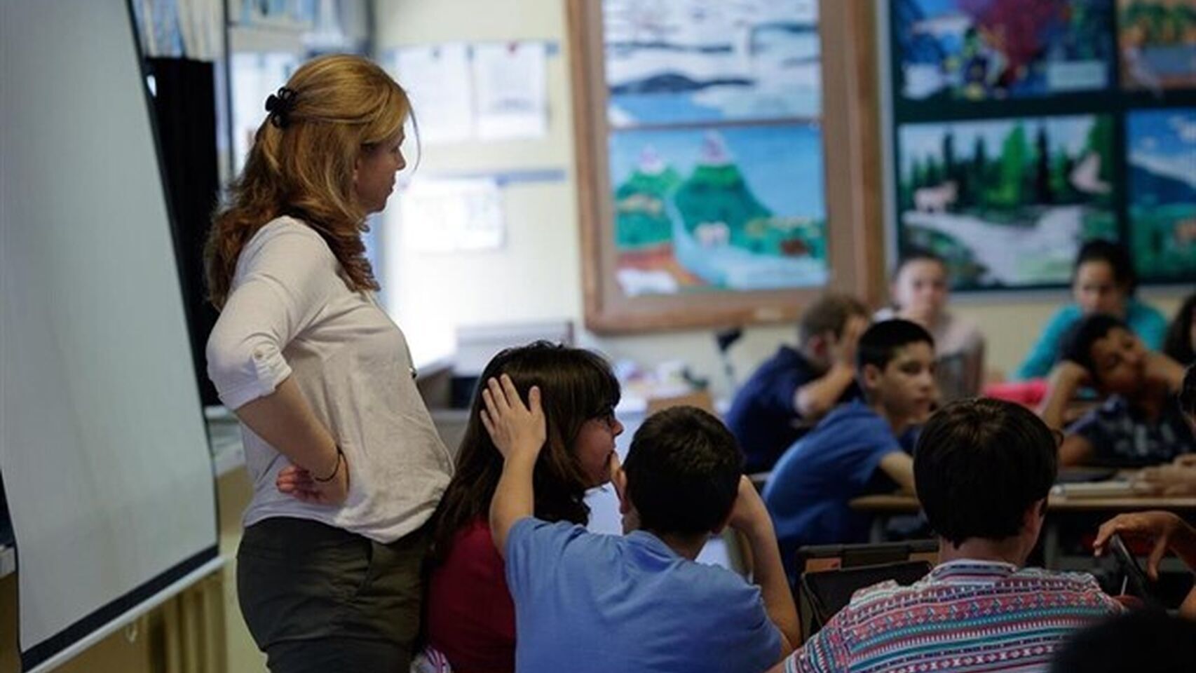 Profesora dando clase en un aula.