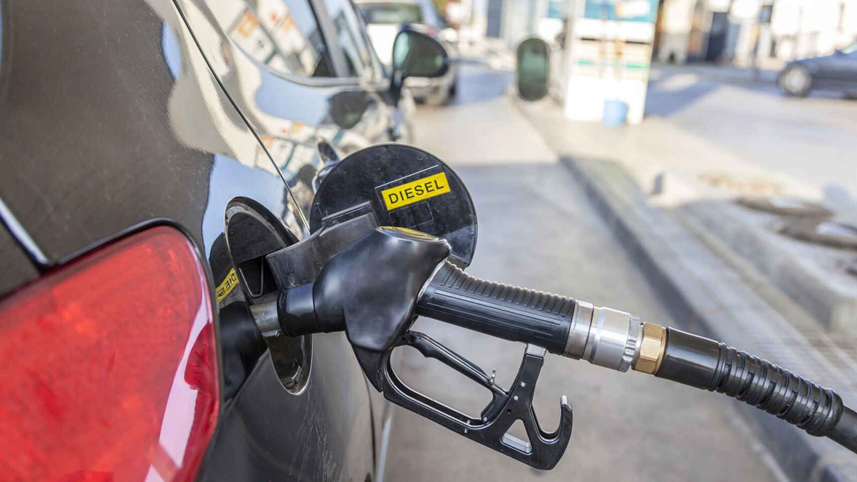 Un coches repostando diésel en una gasolinera.