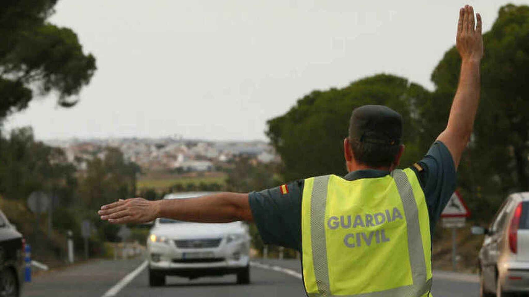 Un agente de la Guardia Civil indica a un coche que se detenga.