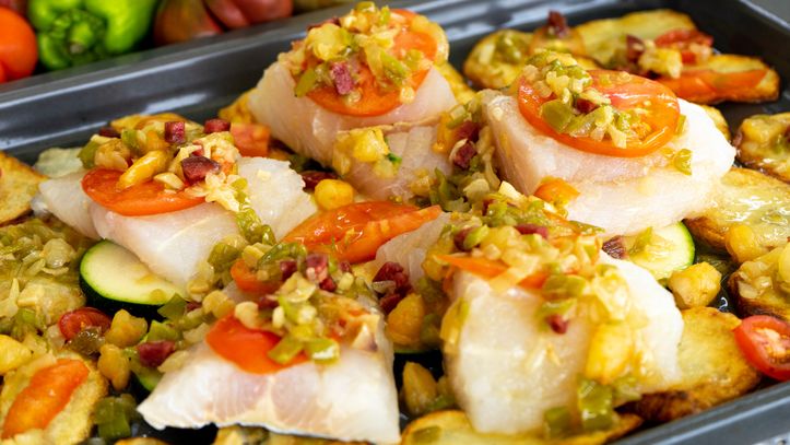 Imagen de archivo de un plato de merluza al horno con verduras.