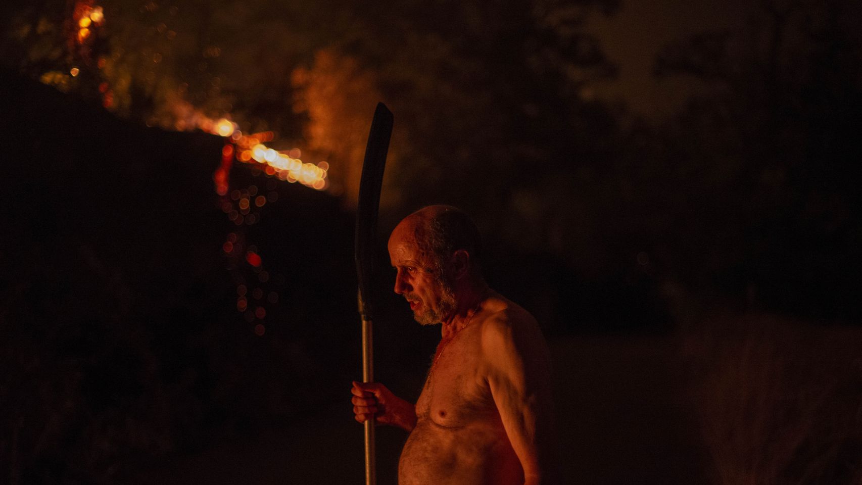 Un hombre observa el fuego del incendio forestal de O Barco de Valdeorras, Galicia.